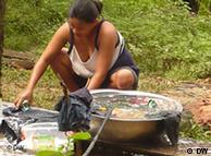A woman washes clothes in a water bucket
